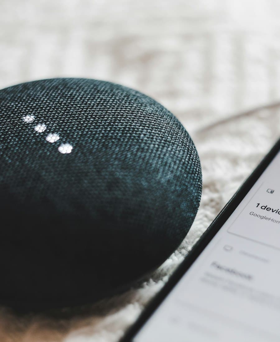 A smart speaker beside a phone, two of the surfaces voice search optimisation targets